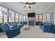 Beautiful sunroom with a stone fireplace, large windows, a ceiling fan, and comfortable blue seating area at 3173 Delaware Dr, Denver, NC 28037