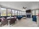 Bright sunroom with large windows, a stone fireplace, TV, ceiling fan, and cozy seating area with dining table at 3173 Delaware Dr, Denver, NC 28037