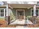 Close-up of a beautiful stained wood front door with glass panels, framed by brick columns and white trim at 318 Lewis Ferry Rd, Statesville, NC 28677