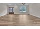 Spacious living room with wood floors, large windows, and a glass-paneled front door, offering ample natural light at 318 Lewis Ferry Rd, Statesville, NC 28677