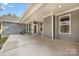 Covered back porch with grey siding, concrete flooring, and space for outdoor seating at 326 Lewis Ferry Rd, Statesville, NC 28677