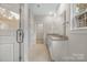 Well-lit bathroom with a double vanity, granite countertops, and a tile floor leading to a walk-in closet at 326 Lewis Ferry Rd, Statesville, NC 28677