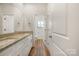 Well-lit bathroom with double vanity, granite countertop, wood flooring and white cabinets at 326 Lewis Ferry Rd, Statesville, NC 28677