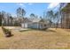 Side view of the home features a two-car garage, manicured lawn, and well-maintained landscaping at 326 Lewis Ferry Rd, Statesville, NC 28677