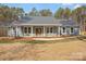 Attractive home featuring large windows, a covered porch, and well-maintained lawn at 326 Lewis Ferry Rd, Statesville, NC 28677