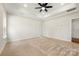 A spacious main bedroom with a tray ceiling, a ceiling fan, carpet floors, and plenty of natural light from its windows at 326 Lewis Ferry Rd, Statesville, NC 28677