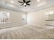 A spacious main bedroom with a tray ceiling, a ceiling fan, carpet floors, and two windows for ample natural light at 326 Lewis Ferry Rd, Statesville, NC 28677