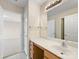 Bright bathroom featuring a wood vanity, large mirror, and doorway into an adjacent bedroom at 3465 Caldwell Ridge Pkwy, Charlotte, NC 28213