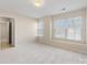 Carpeted bedroom featuring large windows, neutral paint, and an open doorway to a hall at 3465 Caldwell Ridge Pkwy, Charlotte, NC 28213