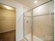 Modern bathroom featuring a glass-enclosed shower and neutral-toned tiles at 3628 Benseval Ln, Matthews, NC 28104