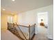 Upstairs hallway featuring a decorative railing and views into the bedrooms at 3628 Benseval Ln, Matthews, NC 28104