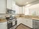 Kitchen with stainless steel appliances, granite countertops, white cabinets and hardwood floors at 3628 Benseval Ln, Matthews, NC 28104