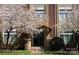 Charming brick building entrance with blooming trees, and planters flanking the walkway at 404 N Laurel Ave # 28, Charlotte, NC 28204