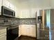 Bright kitchen with stainless steel appliances, gray backsplash, and ample cabinet space at 404 N Laurel Ave # 28, Charlotte, NC 28204