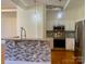 Open-concept kitchen with a breakfast bar, modern appliances, and stylish backsplash, ideal for cooking and socializing at 404 N Laurel Ave # 28, Charlotte, NC 28204