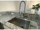 Close-up of a stainless steel kitchen sink with granite countertops and modern faucet at 404 N Laurel Ave # 28, Charlotte, NC 28204
