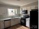 Functional kitchen with white cabinetry, black appliances, and an efficient layout at 4825 Farm Pond Ln, Charlotte, NC 28212