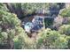 Aerial view of the home, its surrounding wooded acreage, and the pool in the back at 4893 River Hills Dr, Denver, NC 28037