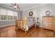 Comfortable bedroom featuring hardwood floors, bright window, dresser and ceiling fan at 4893 River Hills Dr, Denver, NC 28037
