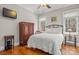Well-lit bedroom features a full sized bed, hardwood floors, and vintage wardrobe at 4893 River Hills Dr, Denver, NC 28037