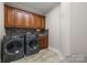 Well-equipped laundry room with modern washer and dryer, plus ample cabinet space at 4893 River Hills Dr, Denver, NC 28037