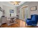 Bright office features an arched glass door, hardwood floors, and a comfortable blue chair at 4893 River Hills Dr, Denver, NC 28037