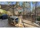 Relaxing outdoor patio with dining set, umbrella, and serene wooded backyard view at 4893 River Hills Dr, Denver, NC 28037