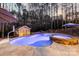 Backyard pool and hot tub illuminated at dusk, surrounded by trees and a shed at 4893 River Hills Dr, Denver, NC 28037