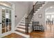 Staircase with a wrought iron railing and hardwood steps at 4893 River Hills Dr, Denver, NC 28037