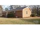 Home's brick exterior with a grassy yard, pine straw, and green bushes at 501 Catawba N Cir, Matthews, NC 28104
