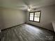 Bedroom with neutral paint, gray flooring, a ceiling fan, and a window overlooking a green space at 501 Catawba N Cir, Matthews, NC 28104