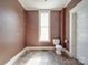 Bathroom featuring a vintage toilet, slate flooring, and brown walls at 505 Camden Rd, Wadesboro, NC 28170