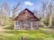 Exterior view of a rustic wooden outbuilding on a large green lawn, set against a backdrop of tall trees at 505 Camden Rd, Wadesboro, NC 28170