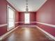 Bright living room with hardwood floors, large windows, and a classic chandelier. The walls are a deep red at 505 Camden Rd, Wadesboro, NC 28170