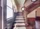 Classic wood staircase featuring detailed wood trim, panelling, and natural light from a nearby window at 505 Camden Rd, Wadesboro, NC 28170