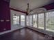 Sunroom with hardwood floors and walls, filled with natural light from the large windows and glass doors at 505 Camden Rd, Wadesboro, NC 28170