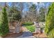 Inviting backyard with lush lawn, decorative stone pillars, and white Adirondack seating surrounding the firepit at 5618 Camilla Dr, Charlotte, NC 28226