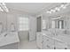 Bright, white bathroom featuring double sinks, white cabinets, and hexagon tile at 5618 Camilla Dr, Charlotte, NC 28226