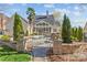 Beautiful home exterior with in-ground pool, lush greenery, mature trees, and a screened-in porch at 5618 Camilla Dr, Charlotte, NC 28226