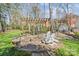 Charming backyard firepit area with pergola and a seating area surrounded by lush lawn and mature trees at 5618 Camilla Dr, Charlotte, NC 28226