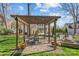 Charming backyard pergola with a dining set, creating a cozy outdoor dining area with views of the pool and fire pit at 5618 Camilla Dr, Charlotte, NC 28226