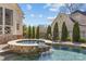 Relaxing in-ground pool with an attached spa featuring a stone surround and gentle waterfall feature at 5618 Camilla Dr, Charlotte, NC 28226