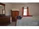 Cozy bedroom featuring a comfortable bed, natural light, and ample storage space in wooden furniture at 648 E Ketchie St, China Grove, NC 28023