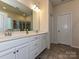Bright bathroom featuring double vanity, large mirror, and tiled floors at 7015 Walnut Branch Ln, Charlotte, NC 28277
