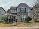 Charming two-story home featuring stone accents, gray siding and meticulously maintained landscaping at 7015 Walnut Branch Ln, Charlotte, NC 28277