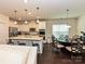 Open-concept kitchen with stainless appliances, white cabinets and island that flows into the dining area at 7015 Walnut Branch Ln, Charlotte, NC 28277