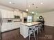 Bright kitchen with stainless appliances, white cabinets, and an expansive island with bar stool seating at 7015 Walnut Branch Ln, Charlotte, NC 28277