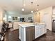 Open-concept kitchen features an island with stainless steel appliances and quartz countertop at 7015 Walnut Branch Ln, Charlotte, NC 28277