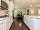 Open kitchen showcasing stainless appliances, white cabinets, island and seamless transition to the dining area at 7015 Walnut Branch Ln, Charlotte, NC 28277