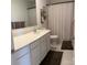 Well-lit bathroom featuring a long countertop vanity, modern fixtures, and a decorative shelf at 705 Hallman Branch Ln, Lincolnton, NC 28092